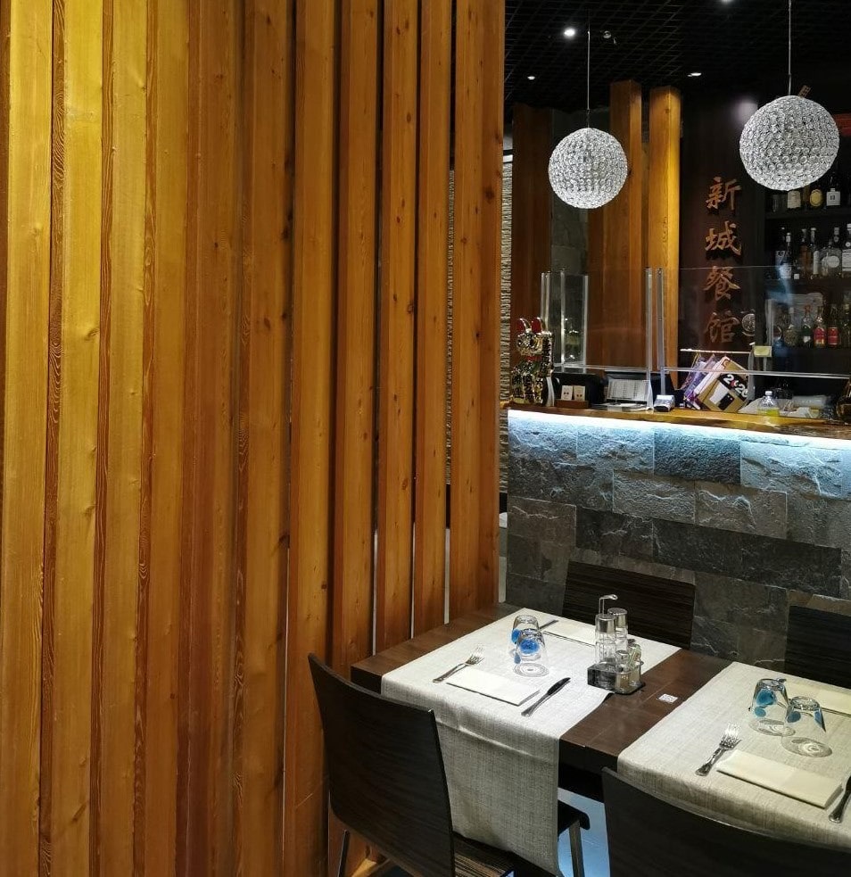 Sala interna del ristorante Castello Nuovo: ambiente Zen con pareti in legno e bancone